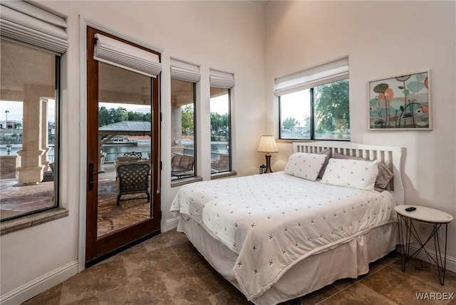 bedroom with access to outside and baseboards