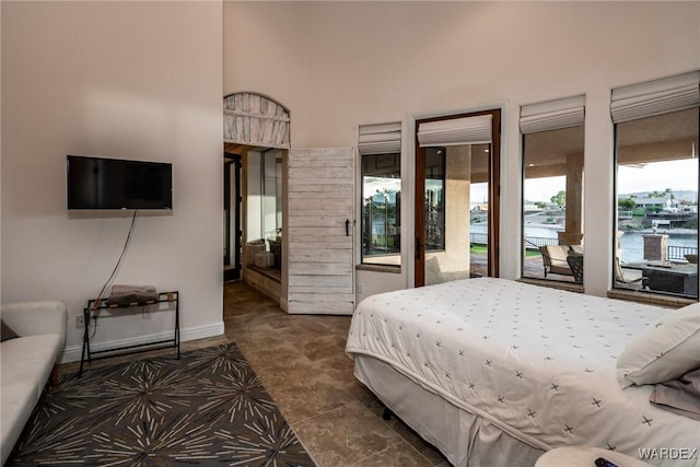 bedroom featuring a water view and baseboards