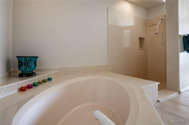 bathroom featuring a garden tub and tile patterned flooring