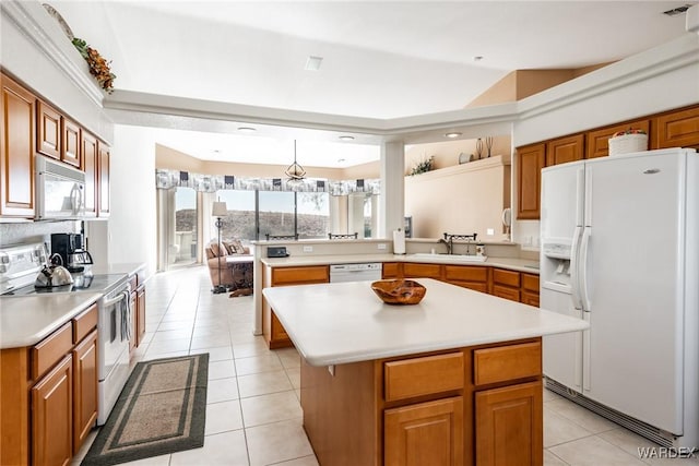 kitchen with a center island, white appliances, light countertops, and a peninsula