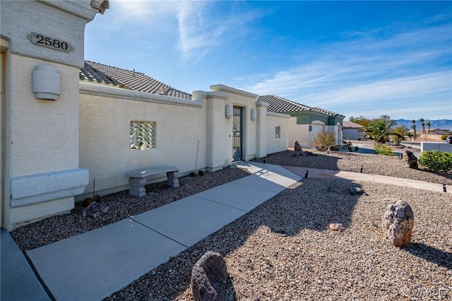 view of property exterior with a tiled roof and stucco siding