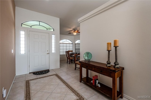 foyer with light tile patterned floors, plenty of natural light, baseboards, and a ceiling fan