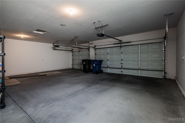 garage featuring a garage door opener and baseboards