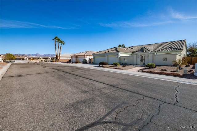 view of front of home featuring a garage, concrete driveway, and a residential view