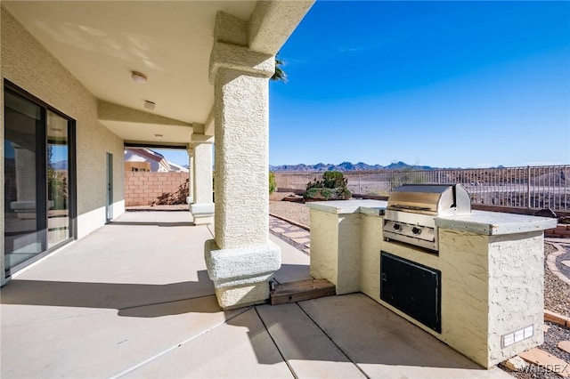 view of patio featuring a grill, a mountain view, a fenced backyard, and area for grilling