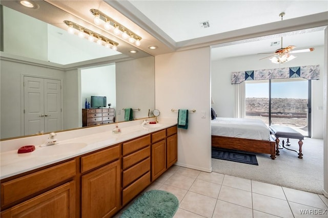 ensuite bathroom with a sink, double vanity, visible vents, and connected bathroom