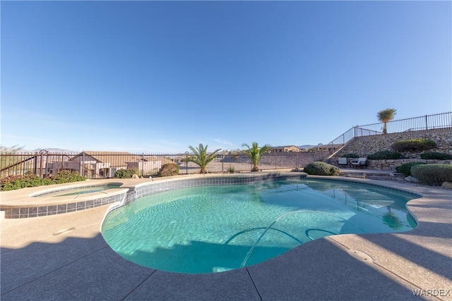 view of pool with a patio, a fenced backyard, and a pool with connected hot tub