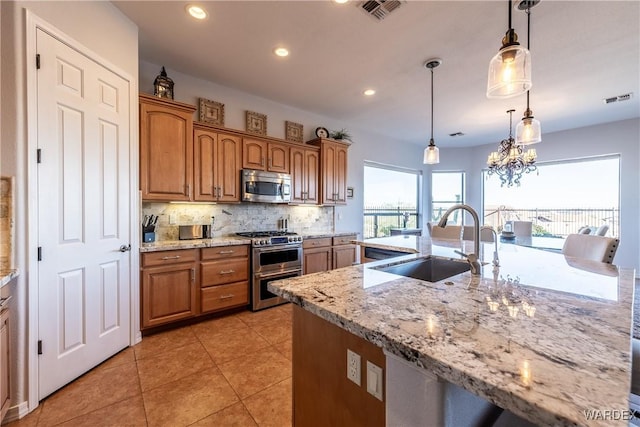 kitchen with stainless steel appliances, visible vents, a sink, and tasteful backsplash