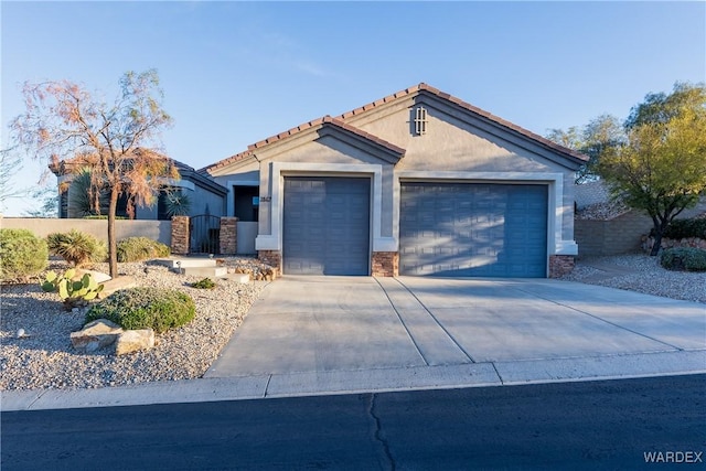 view of front of property with concrete driveway, a fenced front yard, an attached garage, a gate, and stucco siding