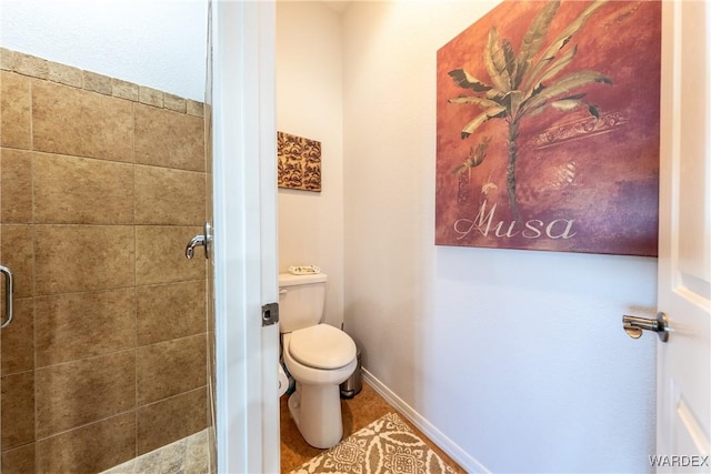 full bathroom with a stall shower, tile patterned flooring, baseboards, and toilet