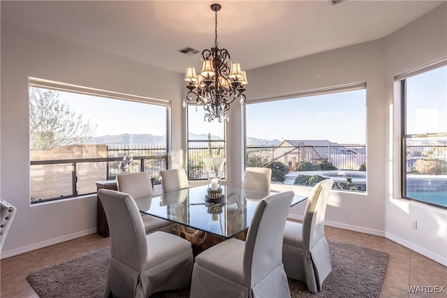 tiled dining room featuring a chandelier, a wealth of natural light, visible vents, and baseboards