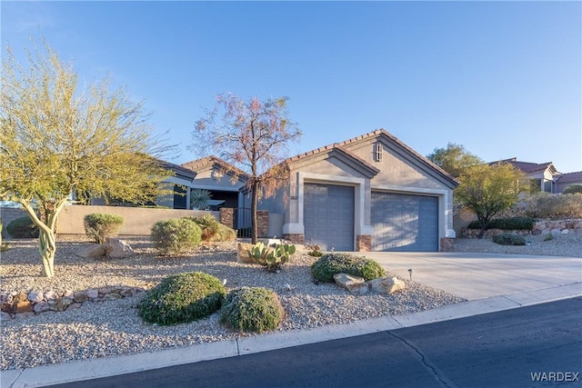 view of front facade with a fenced front yard, stucco siding, concrete driveway, an attached garage, and a tiled roof