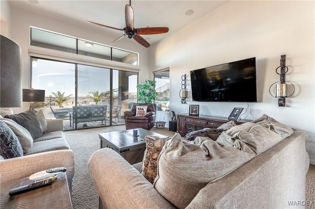 carpeted living room with ceiling fan