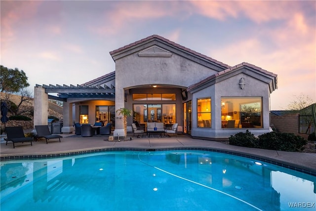 exterior space with stucco siding, an outdoor hangout area, a patio area, an outdoor pool, and a tiled roof