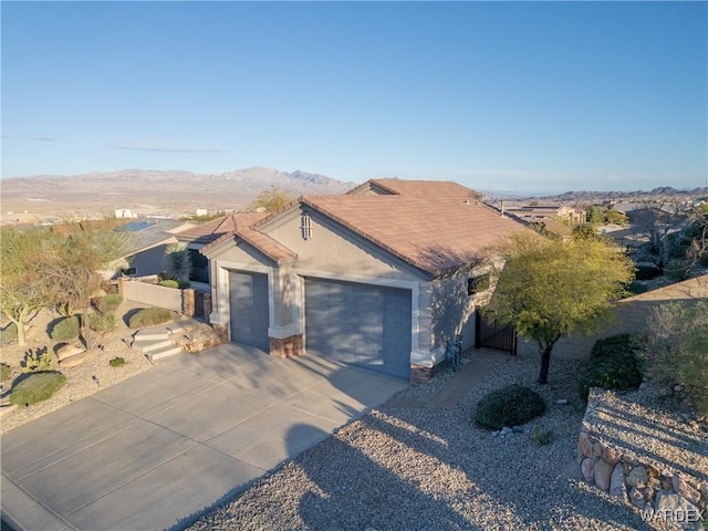 single story home featuring stucco siding, a mountain view, fence, a garage, and driveway