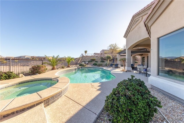 view of pool featuring a patio, a fenced backyard, and a pool with connected hot tub