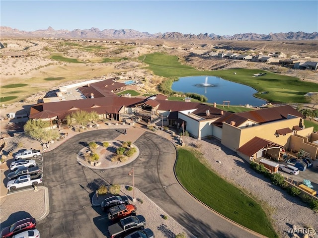 drone / aerial view featuring golf course view, a residential view, and a water and mountain view