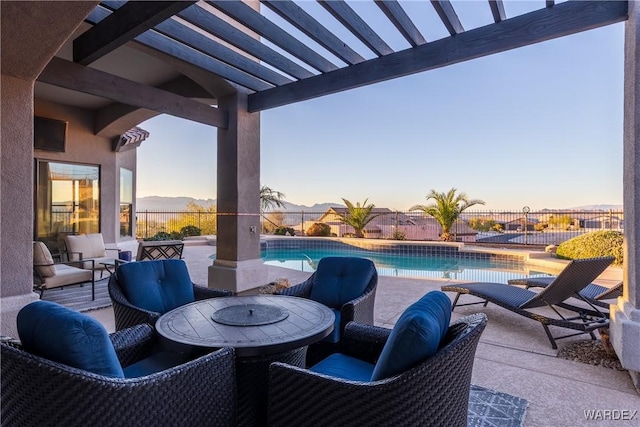 patio terrace at dusk with outdoor dining space, a fenced backyard, and a fenced in pool