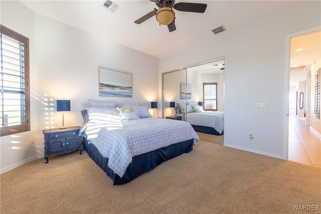 bedroom featuring a closet, light carpet, visible vents, and baseboards