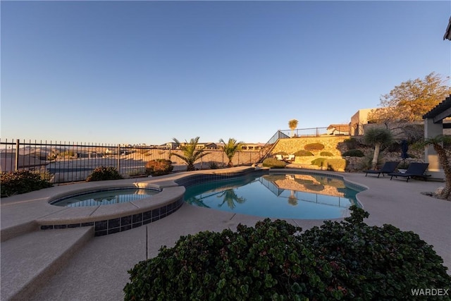 view of swimming pool featuring a patio, a fenced backyard, and a pool with connected hot tub