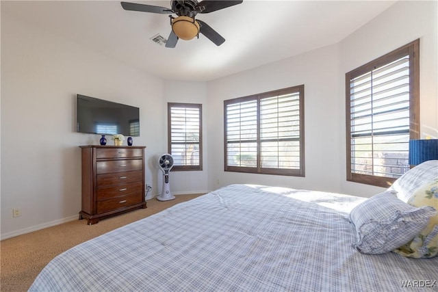 carpeted bedroom with visible vents, ceiling fan, and baseboards