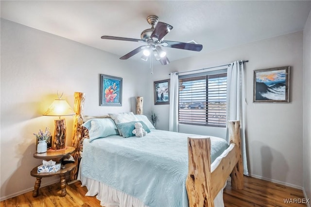 bedroom with baseboards, a ceiling fan, and wood finished floors