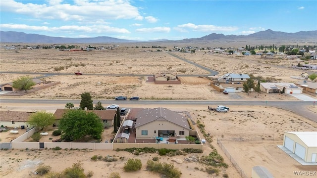drone / aerial view featuring a rural view, view of desert, and a mountain view