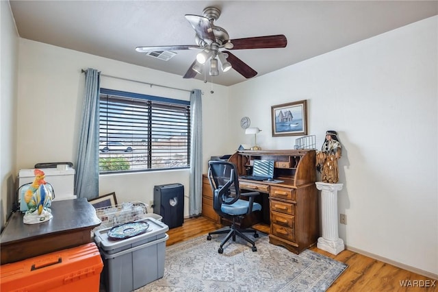 office with wood finished floors, visible vents, a ceiling fan, and baseboards