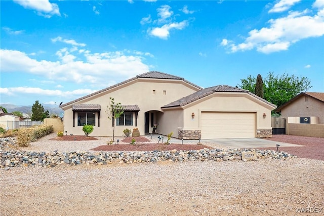 single story home featuring stucco siding, fence, driveway, and a garage