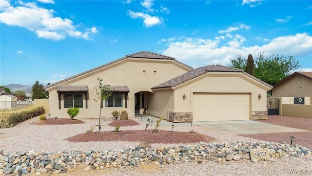 ranch-style house featuring a garage, a tiled roof, stucco siding, and fence