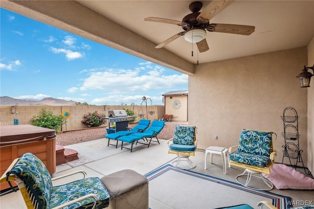 view of patio / terrace featuring a fenced backyard, a hot tub, ceiling fan, and area for grilling
