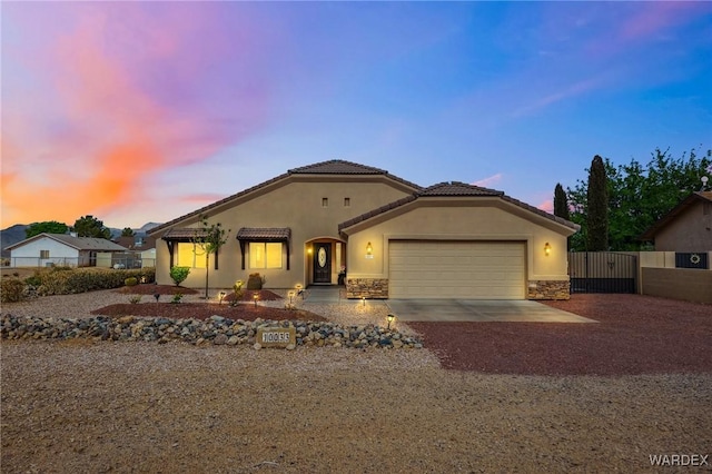 single story home with a gate, driveway, stone siding, fence, and an attached garage