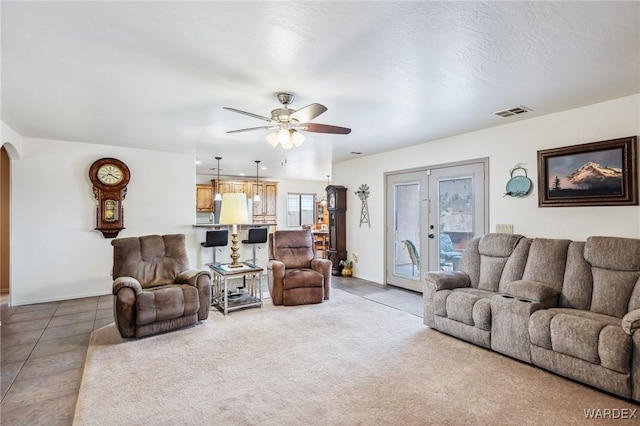 living room featuring visible vents, a ceiling fan, french doors, arched walkways, and baseboards