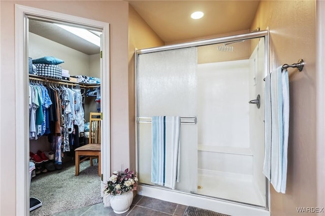 full bath featuring a walk in closet, tile patterned flooring, and a stall shower