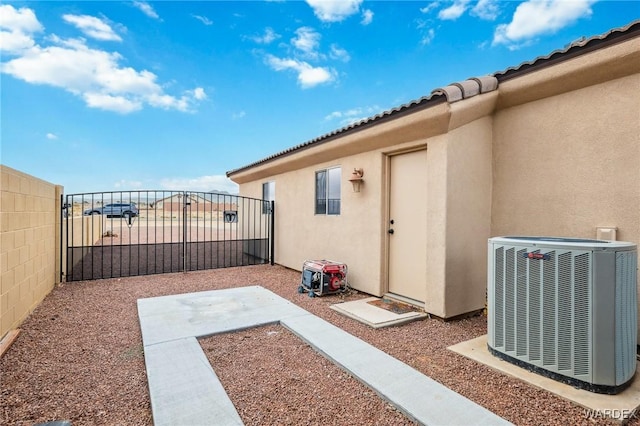 view of patio featuring a gate, central AC unit, and fence