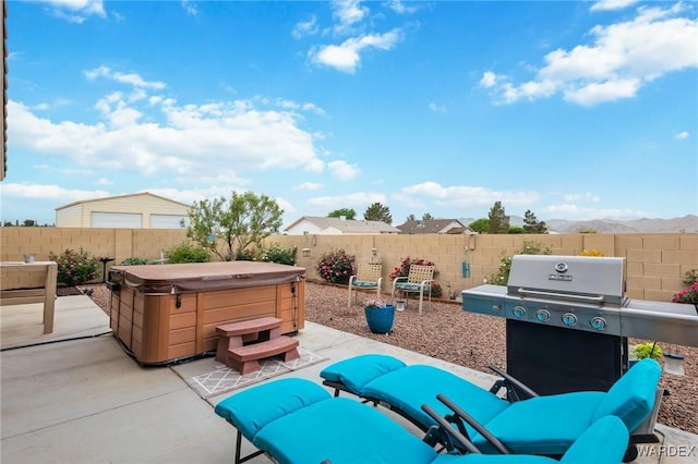 view of patio featuring a fenced backyard, a hot tub, and grilling area