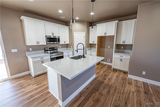 kitchen featuring appliances with stainless steel finishes, light wood-style floors, white cabinets, and a sink