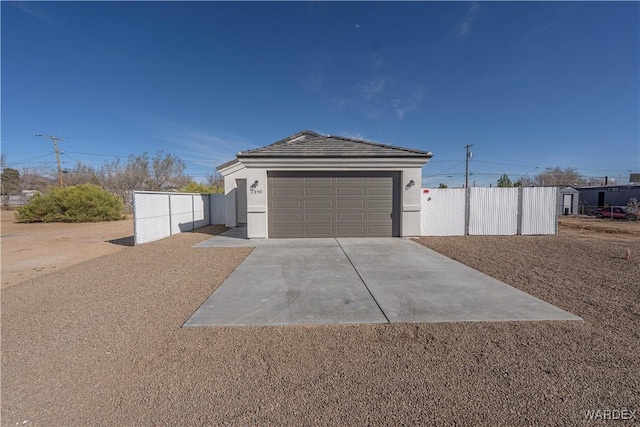 garage with driveway and fence