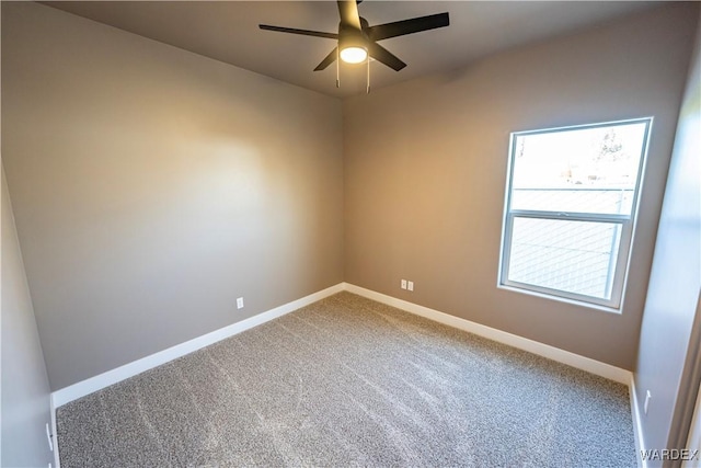 carpeted spare room with a ceiling fan and baseboards