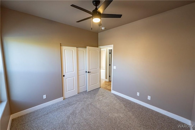 unfurnished bedroom with a ceiling fan, carpet, a closet, and baseboards