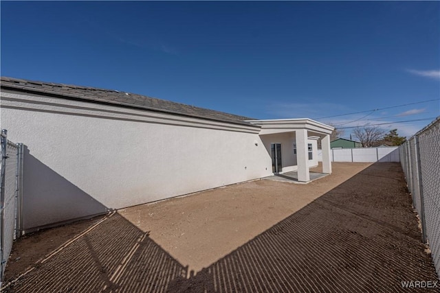 back of house featuring a patio, a fenced backyard, and stucco siding