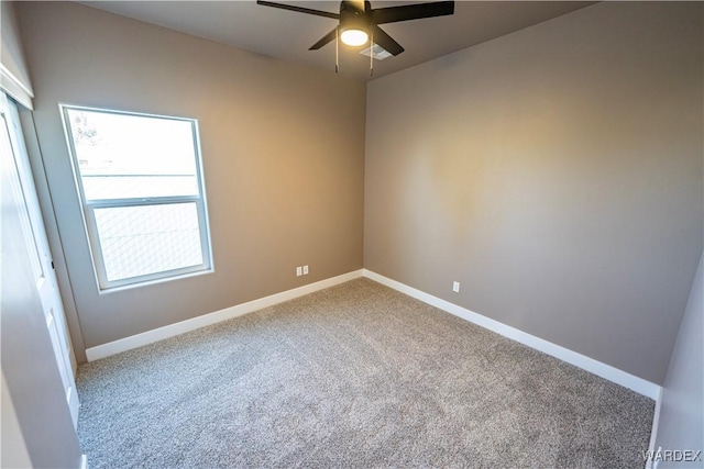 empty room with ceiling fan, carpet, and baseboards