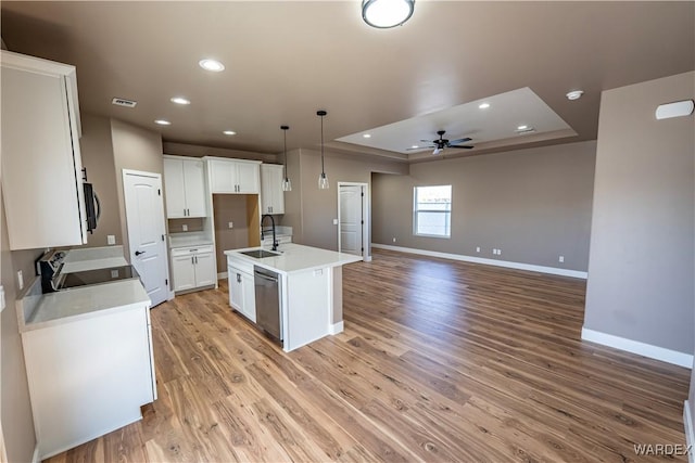 kitchen featuring stove, a sink, visible vents, dishwasher, and a raised ceiling