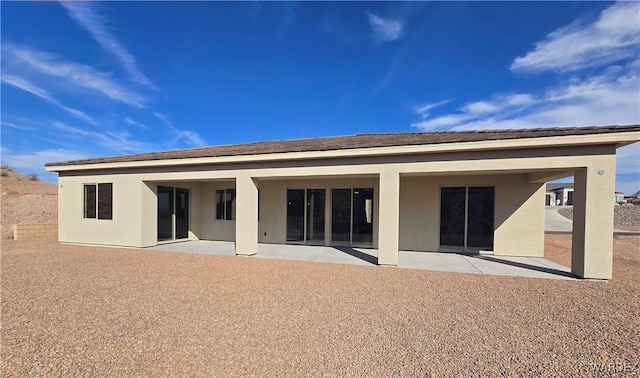 rear view of property with a patio and stucco siding