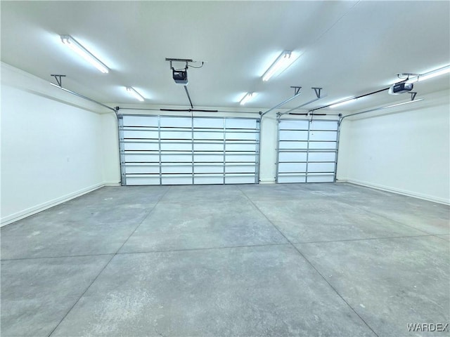 garage with baseboards and a garage door opener