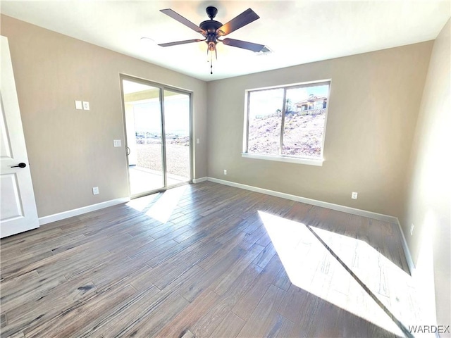 empty room with ceiling fan, wood finished floors, and baseboards