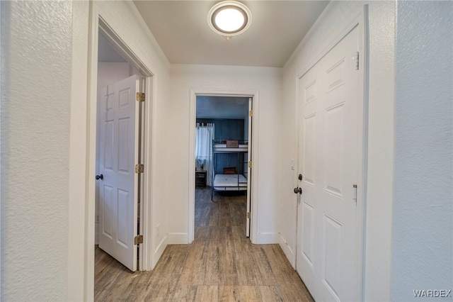 hall featuring wood finished floors and baseboards