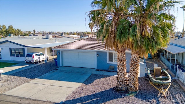 view of front of house with driveway, a tiled roof, an attached garage, and stucco siding