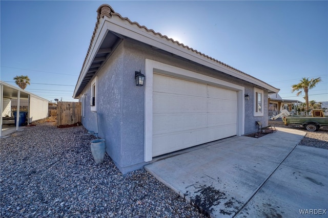 garage with driveway and fence