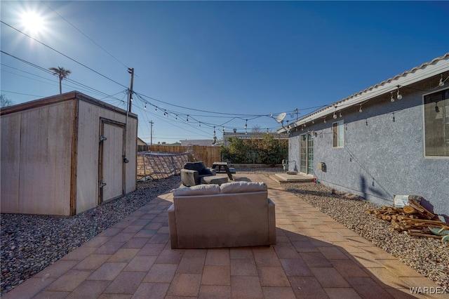 view of patio featuring a fenced backyard, an outdoor structure, an outdoor living space, and a storage shed